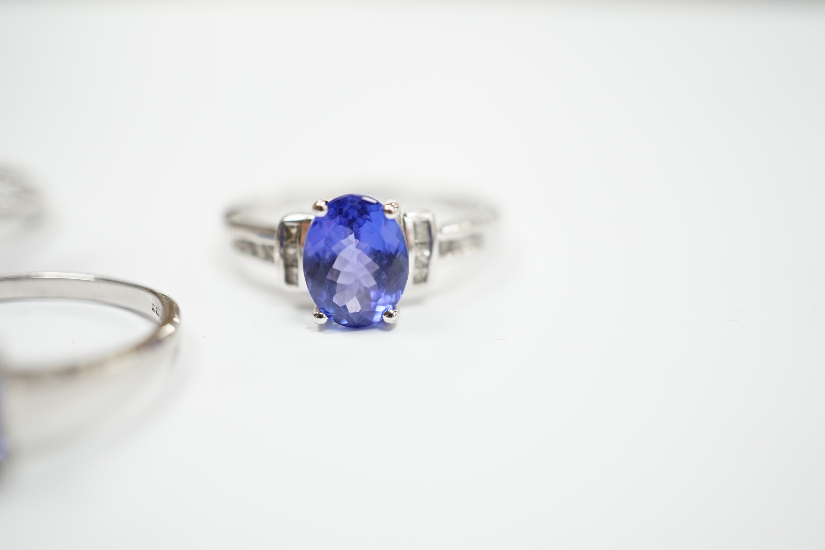 Three assorted modern 9ct white gold and tanzanite set dress rings, gross weight 8.4 grams.